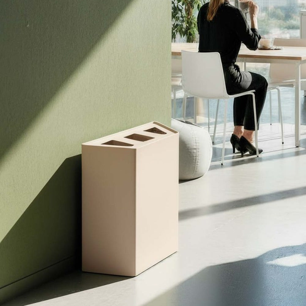 Cestino LINEAR di Caimi avorio chiaro accostato alla parete di un ufficio