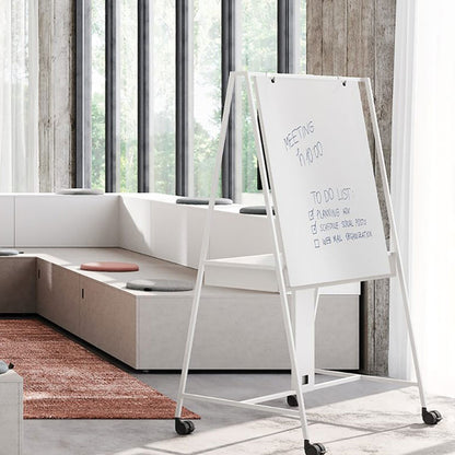 Lavagna mobile AGILE Frezza con telaio in acciaio bianco su ruote e pannello scrivibile in un'area lounge