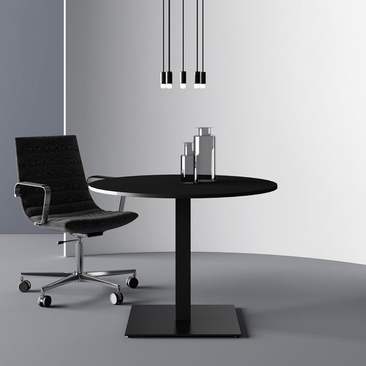 Tavolo tondo POP Frezza con piano nero su colonna e base quadrate nere, con una sedia direzionale