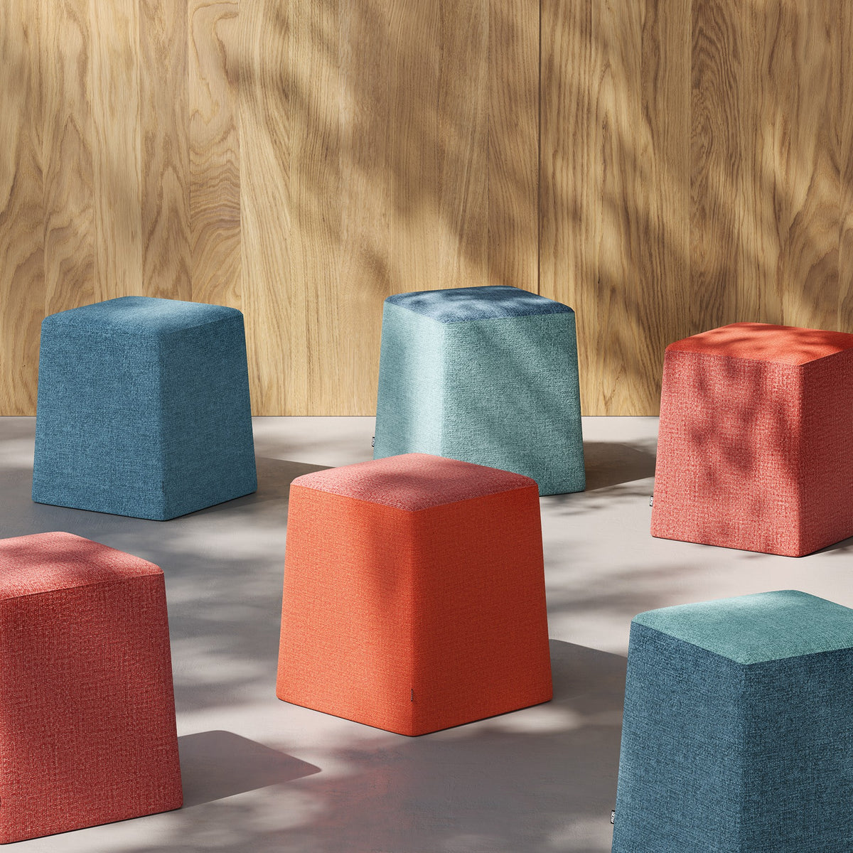 Pouf STAND BY Frezza colorati davanti a una parete in legno
