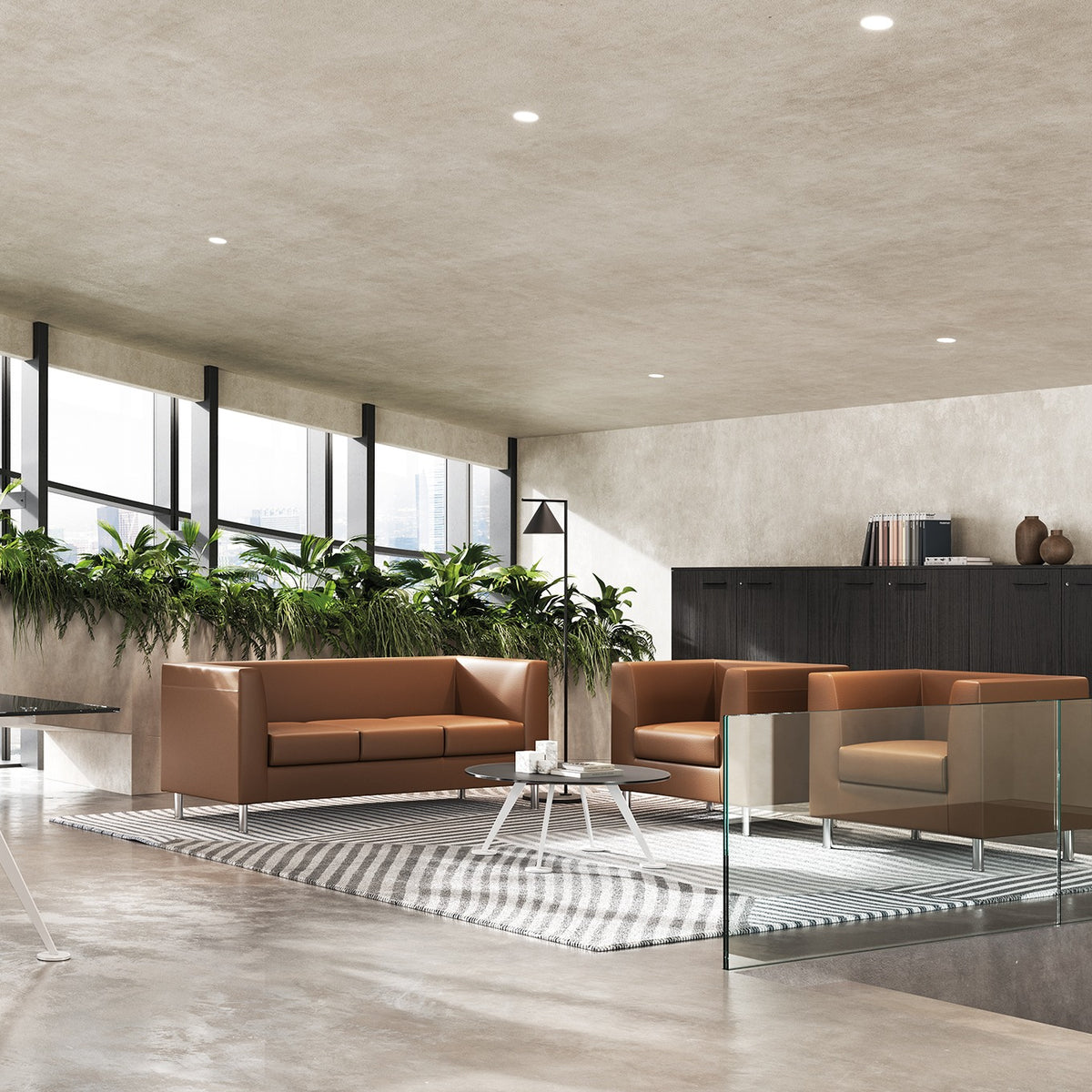 Tavolino caffè SPIKE Frezza tondo con piano in vetro tra divani in pelle in una lounge direzionale