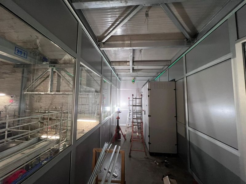 Interno del box di controllo sopraelevato con pareti in pannelli e vetrate, in fase di montaggio