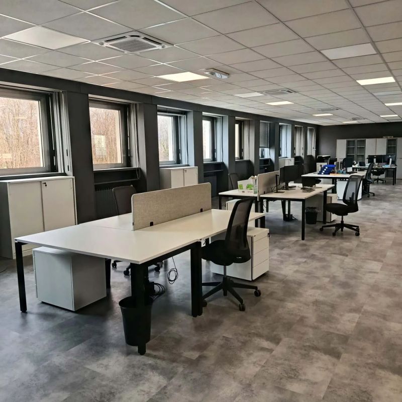 Open space rinnovato con scrivanie operative, armadi e pavimento in gres grigio