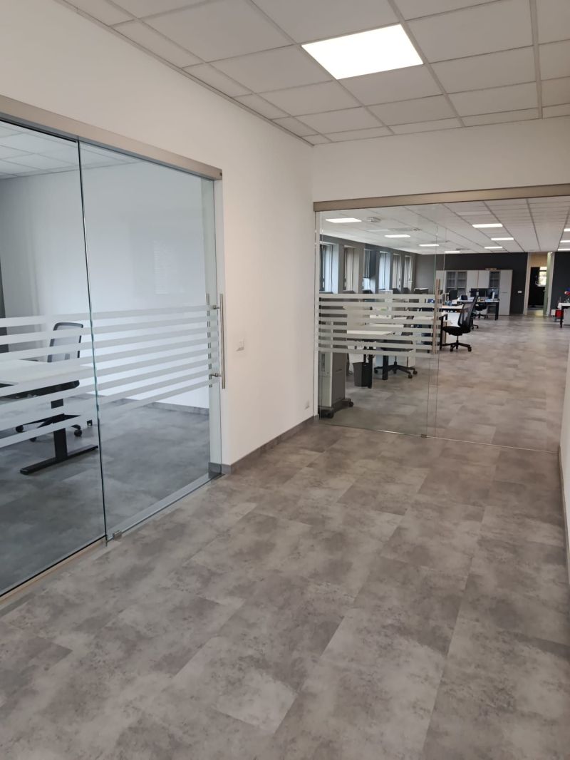 Ufficio rinnovato con pareti vetrate a filo pavimento con fasce satinate