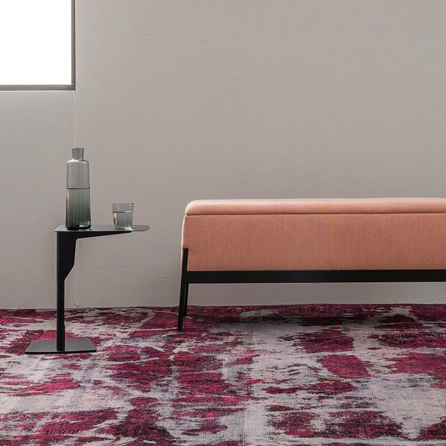 Tavolino ELLE Metal Table Frezza nero accanto a una panca imbottita